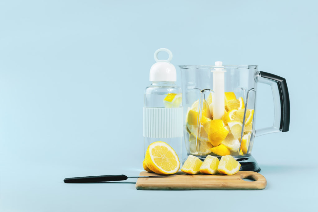Lemon,Water,Glass,Bottle,And,A,Blender,Full,Of,Bright
