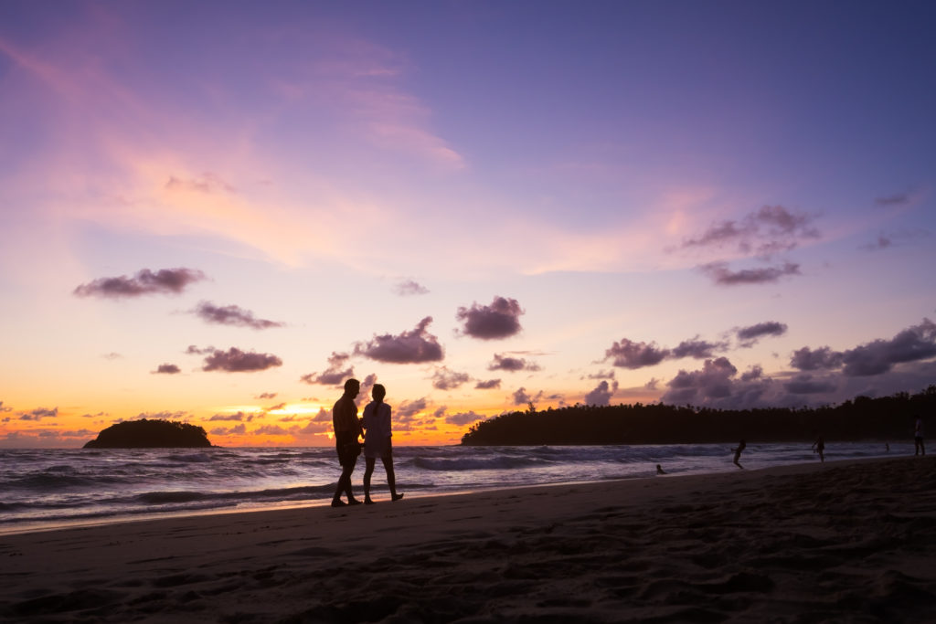 Couple,Walking,On,The,Beach,At,Sunset.